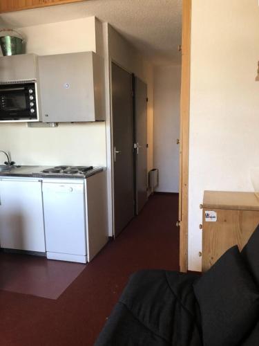 Il comprend une petite cuisine équipée d'une cuisinière et d'un réfrigérateur. dans l'établissement Résidence Skisun - APPARTEMENT ALPE D'HUEZ CENTRE STATION MAE-2271, à Huez