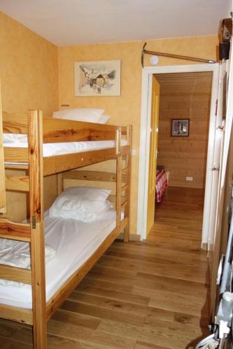 Cette chambre comprend 2 lits superposés et un couloir. dans l'établissement Résidence Lupins - APPARTEMENT ALPE D'HUEZ CENTRE STAITON MAE-2311, à Huez