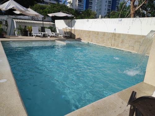 a swimming pool with blue water in a building at Apartamentos Villa Leonor in Coveñas