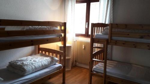 une chambre avec deux lits superposés et une fenêtre dans l'établissement Résidence Alpe 2000 - APPARTEMENT ALPE D'HUEZ HAUT DE STATION MAE-2341, à Huez