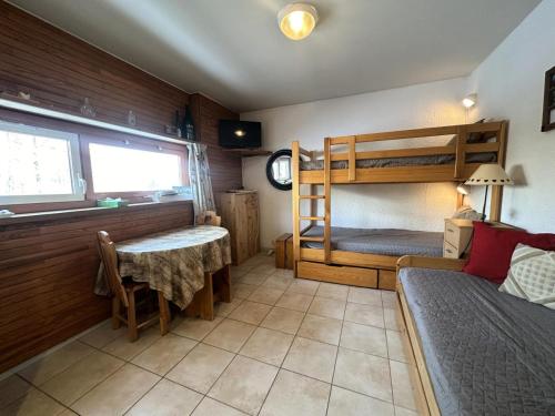 a bedroom with bunk beds and a table and a bed at Résidence Le Pelvoux I - RESIDENCE LE PELVOUX I MAE-0031 in Vars