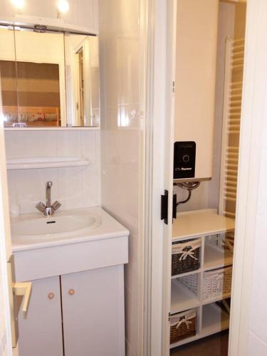 une salle de bain blanche avec un lavabo et un miroir dans l'établissement Résidence Meije - APPARTEMENT ALPE D'HUEZ CENTRE STATION MAE-2411, à Huez