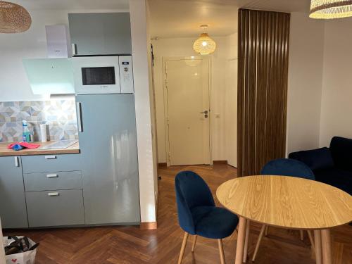 - une cuisine avec une table et des chaises bleues dans la chambre dans l'établissement Elégant studio de 25m2, à Saint-Laurent-du-Var