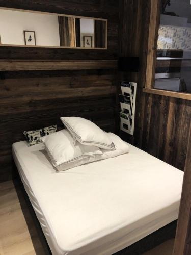 un lit avec des draps blancs et des oreillers dans une chambre dans l'établissement Résidence Res.de L Oisans - APPARTEMENT ALPE D'HUEZ PROCHE CENTRE STATION MAE-2451, à Huez