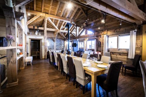 une salle à manger avec une longue table et des chaises dans l'établissement Les Chalets Du Cocoon - CHALET COCOON MAE-1611, à Aime La Plagne