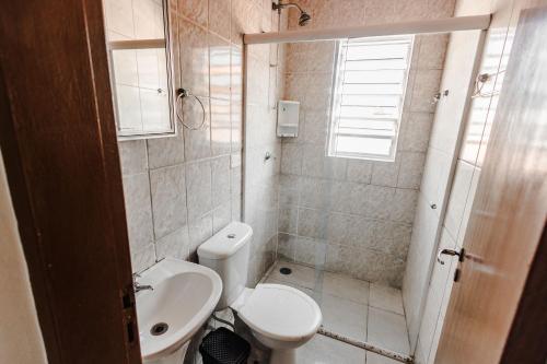 a small bathroom with a toilet and a sink at Tayá Hospedagens in Ubatuba