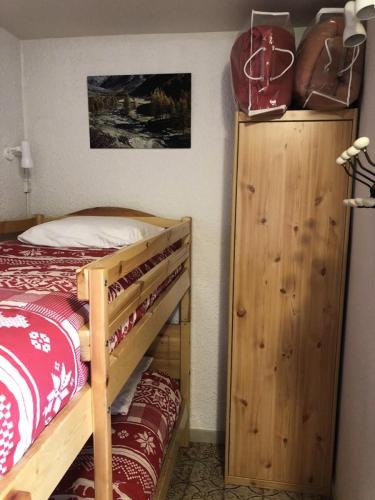 - une chambre avec des lits superposés et une armoire en bois dans l'établissement Résidence Gemeaux - APPARTEMENT ALPE D'HUEZ AVENUE DU RIF NEL MAE-2461, à Huez
