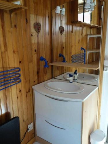 La salle de bains est pourvue d'un lavabo blanc et de murs en bois. dans l'établissement Résidence Lupins - APPARTEMENT ALPE D'HUEZ QUARTIER CENTRE STATION MAE-2511, à Huez