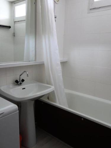 une salle de bain avec un lavabo et un rideau de douche dans l'établissement Résidence Kandahar - APPARTEMENT ALPE D'HUEZ AVENUE DU RIF NEL MAE-2521, à Huez