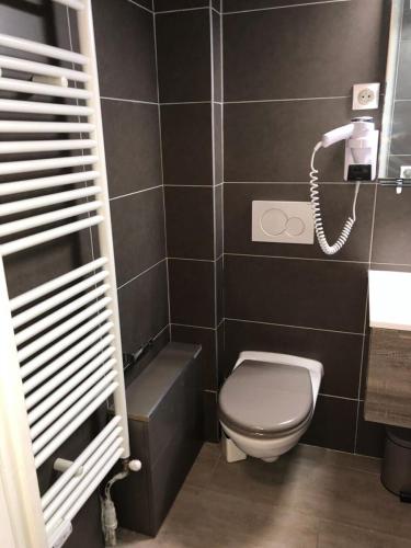 Elle comprend une petite salle de bains pourvue de toilettes et d'un téléphone. dans l'établissement Résidence Sures A - APPARTEMENT ALPE D'HUEZ PROCHE CENTRE STATION MAE-2561, à Huez
