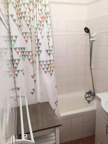 La salle de bains est pourvue d'un rideau de douche et d'une baignoire. dans l'établissement Résidence Olympiades B - APPARTEMENT ALPE D'HUEZ CENTRE STATION MAE-2581, à Huez