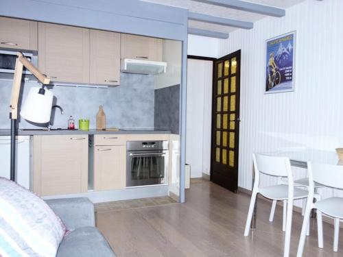 une cuisine et une salle à manger avec une table et des chaises dans l'établissement Résidence Samovar - APPARTEMENT ALPE D'HUEZ CENTRE STATION MAE-2591, à Huez