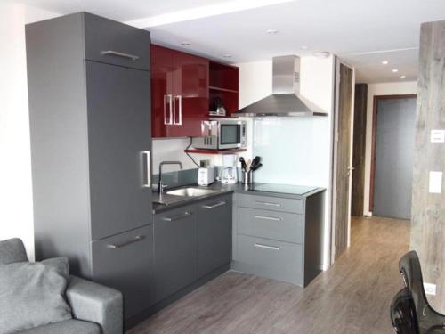 - une cuisine avec des placards rouges et blancs dans une pièce dans l'établissement Résidence Taburle - APPARTEMENT ALPE D'HUEZ HAUT DE STATION MAE-2621, à Huez