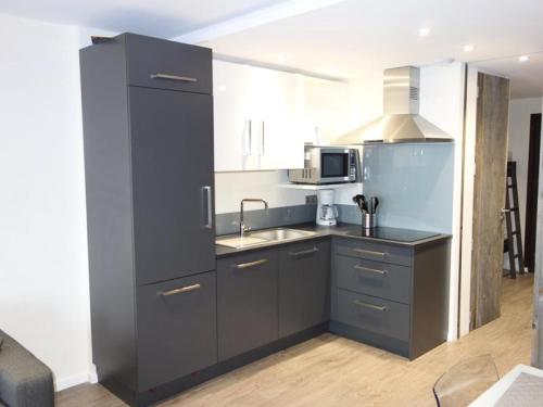 La cuisine est équipée d'un réfrigérateur noir et d'un évier. dans l'établissement Résidence Taburle - APPARTEMENT ALPE D'HUEZ HAUT DE STATION MAE-2611, à Huez