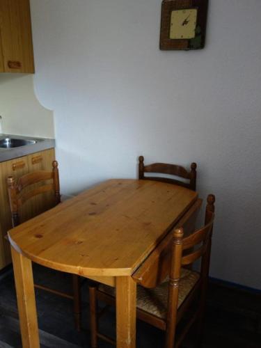 - une table et des chaises en bois dans la cuisine dans l'établissement Résidence Val D'huez - APPARTEMENT ALPE D'HUEZ QUARTIER ECLOSE MAE-2631, à Huez