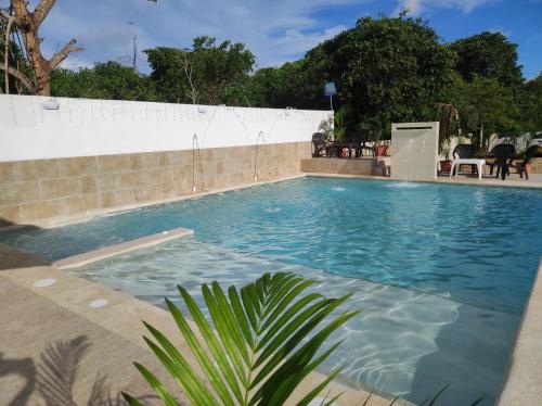 a large swimming pool with blue water at Apartamentos Villa Leonor in Coveñas