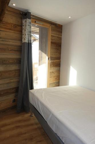 une chambre avec un lit et une porte coulissante en verre dans l'établissement Résidence Taburle - APPARTEMENT ALPE D'HUEZ HAUT DE STATION MAE-2651, à Huez