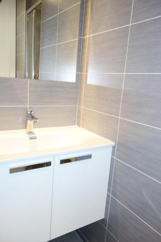 une salle de bain avec un lavabo blanc et un miroir dans l'établissement Résidence Taburle - APPARTEMENT ALPE D'HUEZ HAUT DE STATION MAE-2641, à Huez