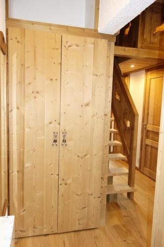 Cette chambre est dotée d'un mur en bois et d'un escalier. dans l'établissement Résidence Richelieu - APPARTEMENT ALPE D'HUEZ RUE DU MAQUIS DE L'OISANS MAE-2691, à Huez