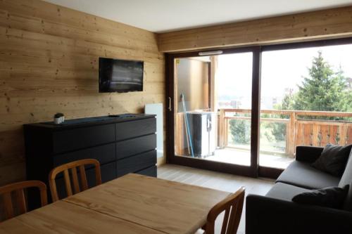 un salon avec une table et une grande fenêtre dans l'établissement Résidence Rousses - APPARTEMENT ALPE D'HUEZ HAUT DE STATION MAE-2721, à Huez