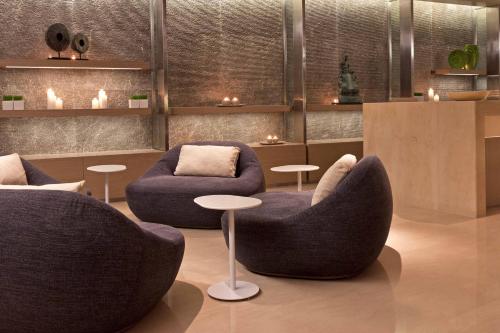 a room with two chairs and a couch and tables at The Westin Gurgaon, New Delhi in Gurgaon