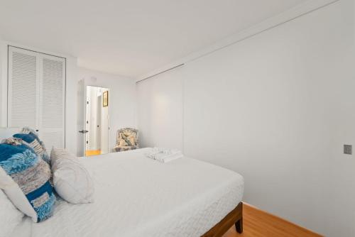 a white bedroom with a bed with pillows on it at Newly Renovated Oceanfront Waikiki- Ilikai Marina in Honolulu