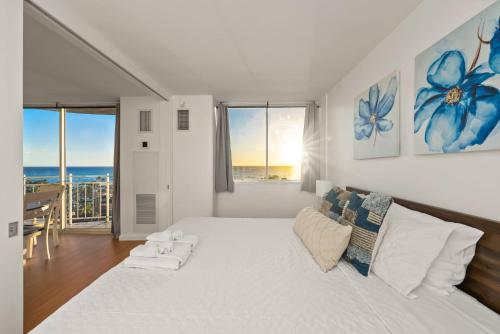 a white bedroom with a large bed and a couch at Newly Renovated Oceanfront Waikiki- Ilikai Marina in Honolulu