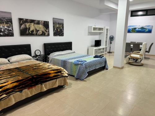 a bedroom with two beds and a tv in it at Apartamento el rebalaje VI in Roquetas de Mar