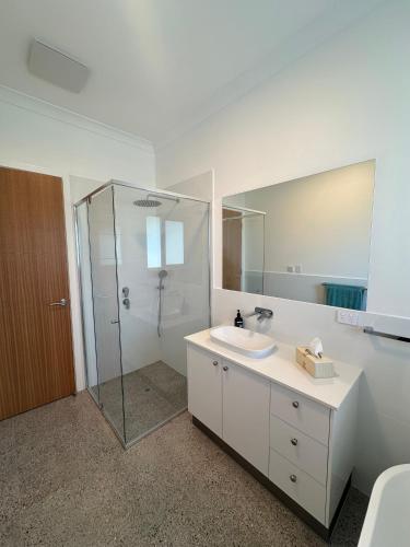 a bathroom with a sink and a shower with a mirror at Middy's in Middleton