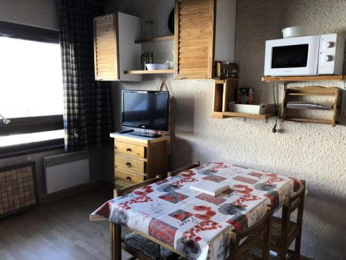 Il comprend un salon doté d'une télévision et d'une table avec un lit. dans l'établissement Résidence Maison De L'alpe - APPARTEMENT ALPE D'HUEZ QUARTIER VIEL ALPE MAE-2981, à Huez