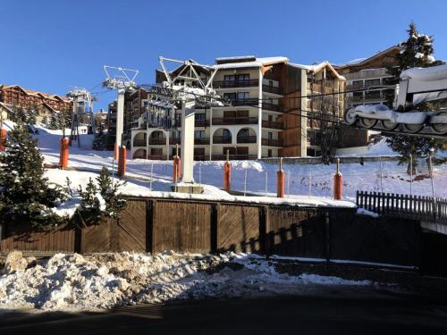 un pont dans la neige devant un bâtiment dans l'établissement Résidence Maison De L'alpe - APPARTEMENT ALPE D'HUEZ QUARTIER VIEL ALPE MAE-2981, à Huez