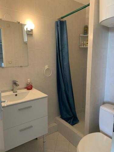 a bathroom with a shower with a blue shower curtain at escapade vue sur le port in Leucate-Plage