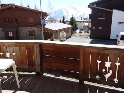 une terrasse dotée d'une clôture en bois avec des bois dans l'établissement Chalet Alpina - APPARTEMENT ALPE D'HUEZ HAUT DE STATION MAE-3021, à Huez