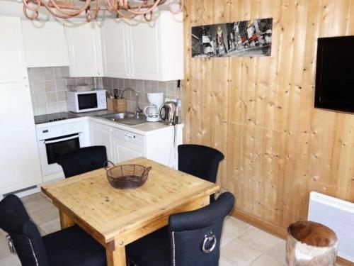 une cuisine avec une table et des chaises en bois dans l'établissement Chalet Alpina - APPARTEMENT ALPE D'HUEZ HAUT DE STATION MAE-3021, à Huez