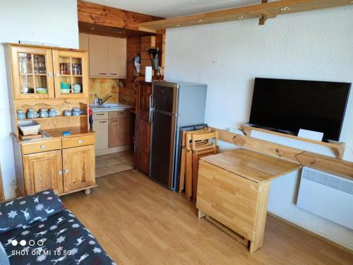 Il comprend une cuisine équipée d'un réfrigérateur et une télévision. dans l'établissement Résidence Dome - APPARTEMENT ALPE D'HUEZ HAUT DE STATION/COGNET MAE-3101, à Huez