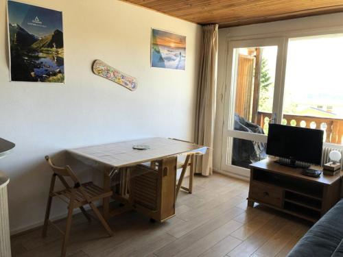 - un salon avec une table et un bureau avec un ordinateur dans l'établissement Résidence Saint Bernard - APPARTEMENT ALPE D'HUEZ CENTRE STATION MAE-3051, à Huez