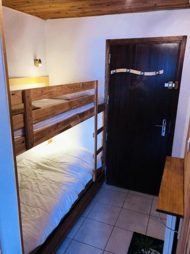 Cette chambre comprend 2 lits superposés et une porte. dans l'établissement Résidence Saint Bernard - APPARTEMENT ALPE D'HUEZ CENTRE STATION MAE-3051, à Huez