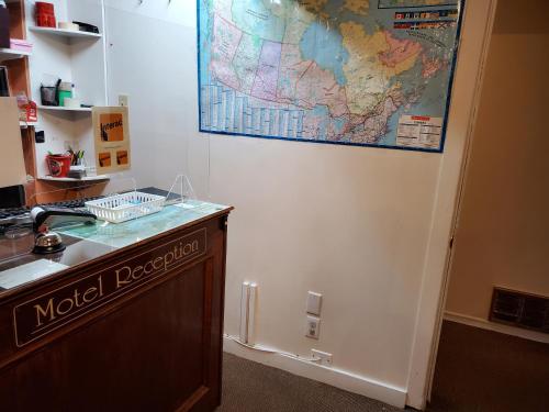 a map hanging on a wall next to a desk at Auberge Eldo Inn in Blind River