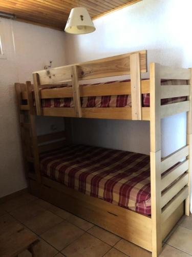 Ce lit superposé en bois se trouve dans un dortoir. dans l'établissement Résidence Meridien - STUDIO DE 35M2 HAUT DE STATION ALPE D'HUEZ MAE-3121, à Huez