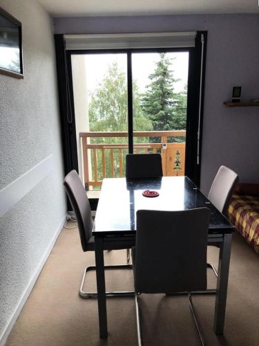 une salle à manger avec une table et des chaises et une fenêtre dans l'établissement Résidence Soleil D'huez - APPARTEMENT ALPE D'HUEZ QUARTIER DE L'ECLOSE EST MAE-3191, à Huez