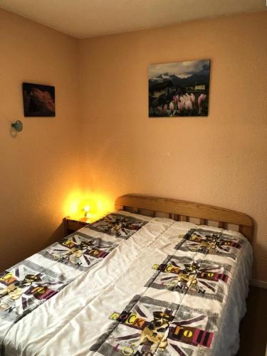 une chambre avec un lit avec une couette dessus dans l'établissement Résidence Soleil D'huez - APPARTEMENT ALPE D'HUEZ QUARTIER DE L'ECLOSE EST MAE-3191, à Huez