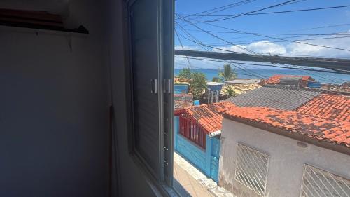 una vista dell'oceano da una finestra di Loft na praia com vista a Itaparica