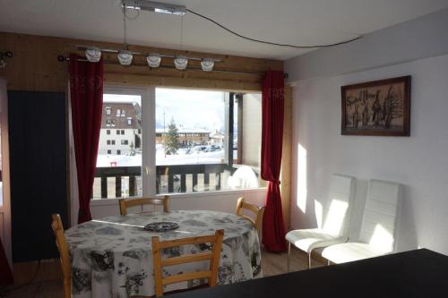 une salle à manger avec une table et des chaises et une fenêtre dans l'établissement Résidence Cabris - APPARTEMENT 3 PIECES- ALPE D'HUEZ COGNET-PIEDS DES PISTES MAE-2951, à Huez