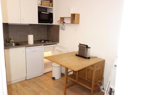 une petite cuisine avec une table en bois et un ordinateur. dans l'établissement Résidence 4 Soleils - APPARTEMENT 2 PIECES + COIN MONTAGNE-ECLOSE EST MAE-3281, à Huez