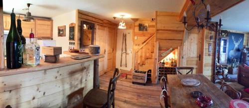 - une salle à manger avec une table et des bouteilles de vin dans l'établissement Résidence Val D'ys - Appartement 3 pièces Centre Station MAE-3211, à Huez