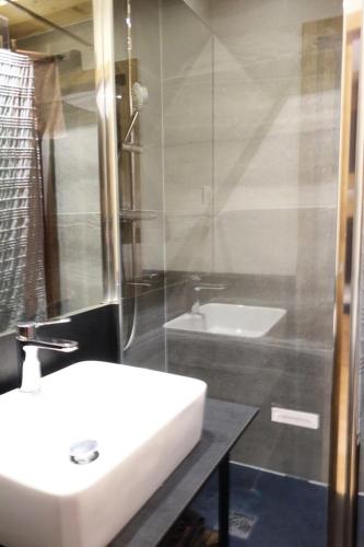 une salle de bain avec un lavabo blanc et une douche dans l'établissement Résidence Menandiere - APPARTEMENT ALPE D'HUEZ CENTRE STATION MAE-3251, à Huez