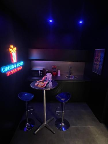 - une cuisine avec une table, deux tabourets et un évier dans l'établissement Cinéma & Jacuzzi, à Vienne