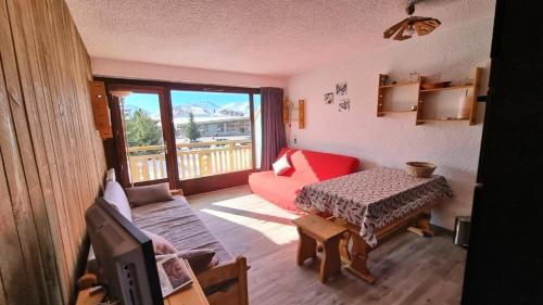 un salon avec un canapé rouge et une table dans l'établissement Résidence Richelieu - APPARTEMENT ALPE D'HUEZ RUE DU MAQUIS DE L'OISANS MAE-3321, à Huez