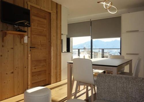 une cuisine et une salle à manger avec une table et des chaises dans l'établissement Résidence Vanessa - APPARTEMENT 3 PIECES + coin montagne HAUT COGNET MAE-3391, à Huez