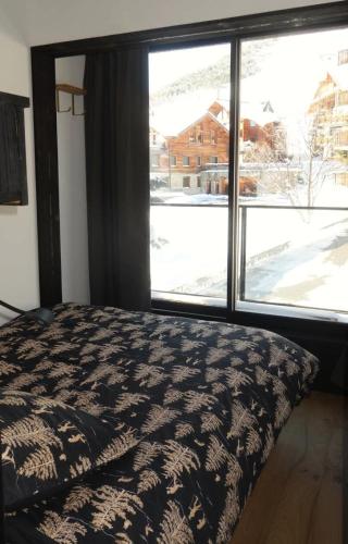 une chambre avec un lit et une grande fenêtre dans l'établissement Résidence Vanessa - APPARTEMENT 3 PIECES + coin montagne HAUT COGNET MAE-3391, à Huez